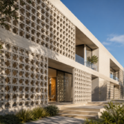 Façade moderne avec résille de béton ajourée créant des jeux d’ombre et de lumière sur un bâtiment contemporain